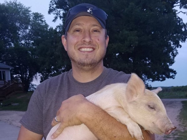 Winner of the 2019 Robert J. Heilman Passion Fund Award, David Storms on his farm holding pig
